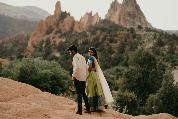 Newlywed couple on scenic red rock mountain ridge